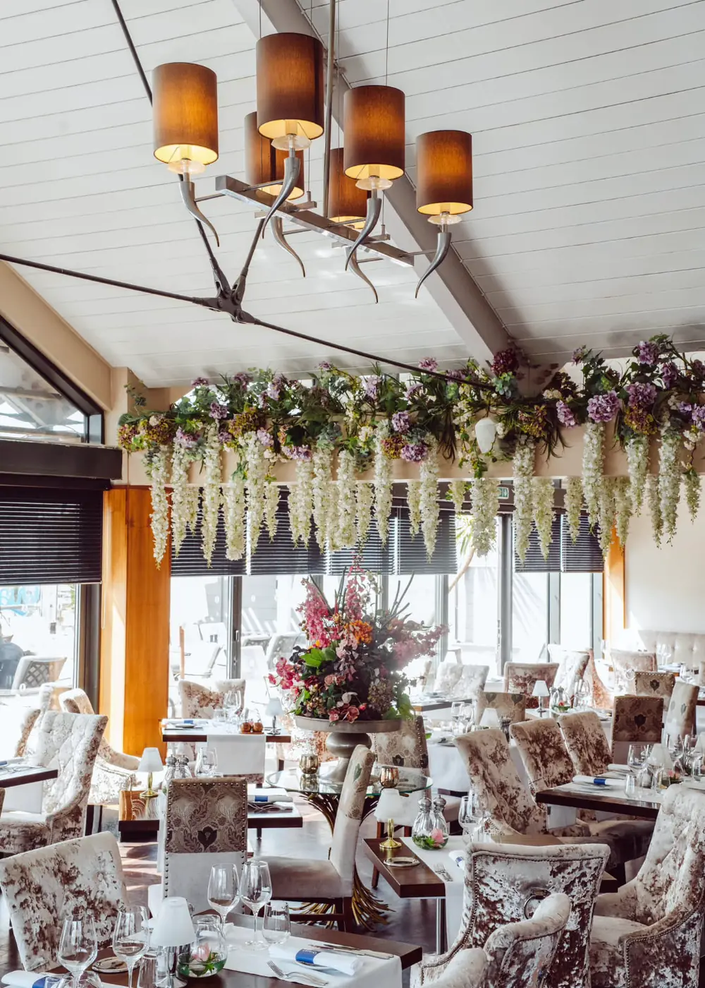 The Quayside dining room, set for service under a ceiling of hanging flowers